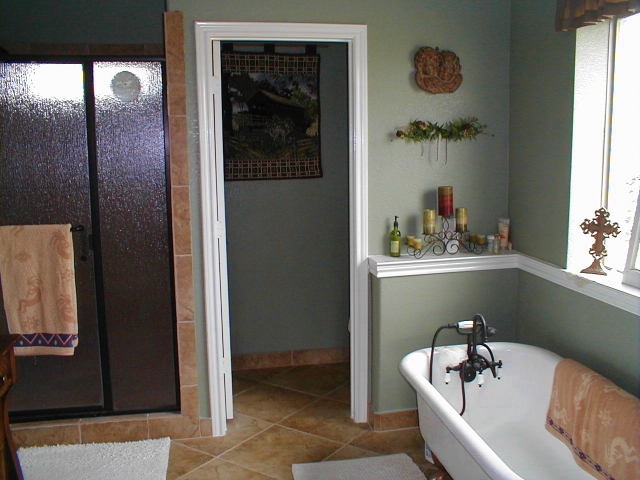Bathroom with clawfoot tub, tile floors, glass shower. #TexasHomesteader