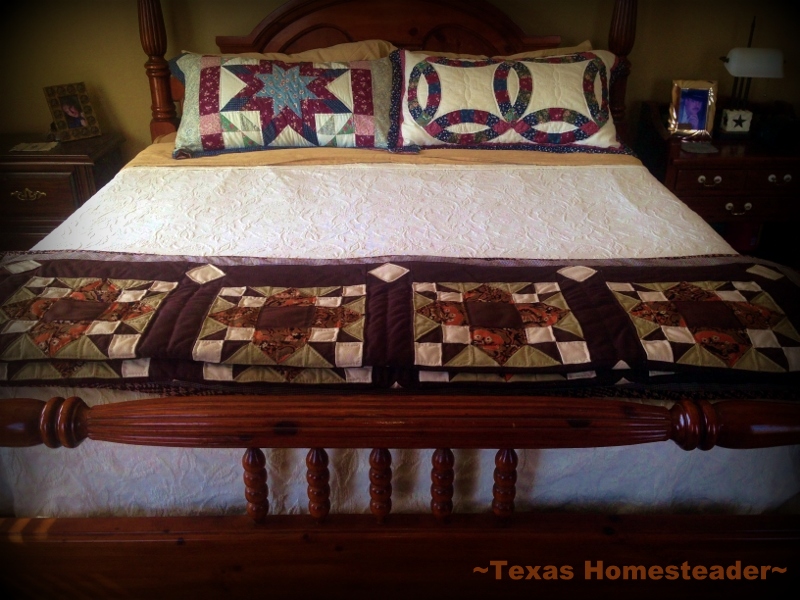 Four poster wood frame bed with vintage spread and hand-made quilt.