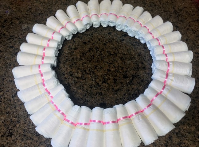 Cute Diaper Wreath Gift For Baby. This gift didn't cost much money but it was hand-made with much love. Items can be pulled from the wreath as needed. #TexasHomesteader