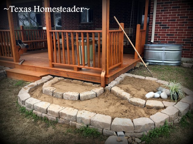 Retaining wall stones and sand footings for support in planting large galvanized water troughs for edible beauty around your home. It's easy and can be done inexpensively too. #TexasHomesteader
