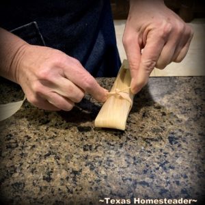 Tying the assembled tamale. It's time consuming to make homemade tamales. But it's very easy. Come see my step-by-step directions complete with photos and recipe. #TexasHomesteader